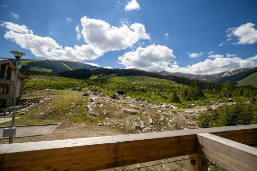 a view of a field with rocks and mountains at Apartmány iziJasná & Chalets in Demanovska Dolina