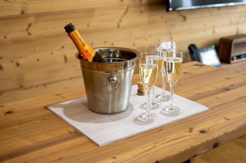 a bucket with a bottle of champagne and glasses on a table at Apartmány iziJasná & Chalets in Demanovska Dolina