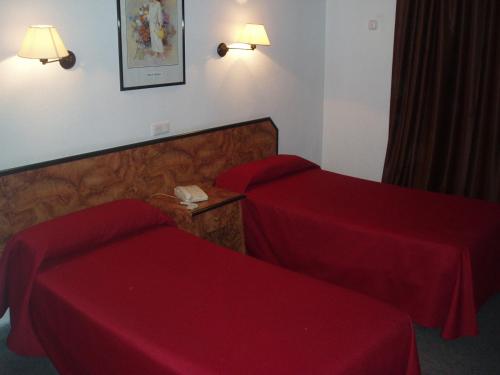 a hotel room with two beds with red sheets at Mont-Park in Benidorm