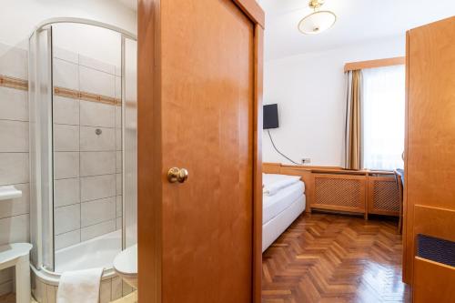 a bathroom with a shower and a toilet and a sink at Boutique Hotel Goldenes Lamm in Villach