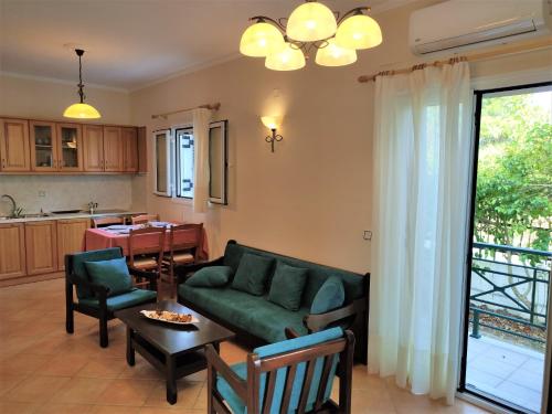 een woonkamer met een groene bank en een tafel bij Oikia Dinachris in Agios Georgios