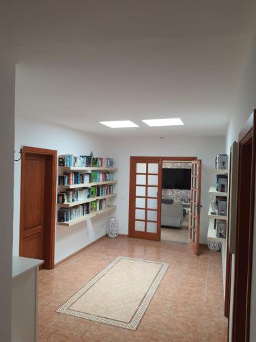 a living room with bookshelves and a room with a door at Villa Feliza in Güime
