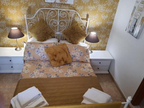 a bedroom with a bed with two tables and two lamps at Villa Feliza in Güime