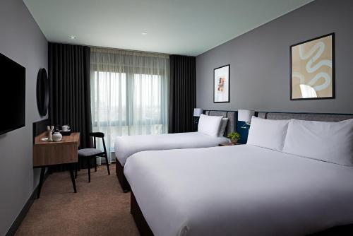 a hotel room with two beds and a desk at George Limerick Hotel in Limerick