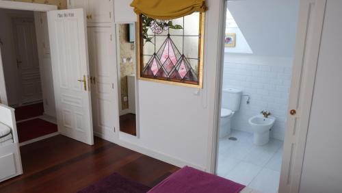 a bathroom with a toilet and a stained glass window at HOTEL LA CASA DE LAS CAMELIAS in Busto