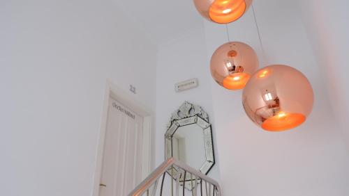 a hallway with three lights and a mirror on the wall at HOTEL LA CASA DE LAS CAMELIAS in Busto