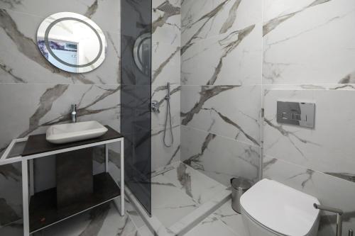 Un baño con inodoro, lavabo y espejo. en GRAFFIT Luxury houses, en Ognyanovo