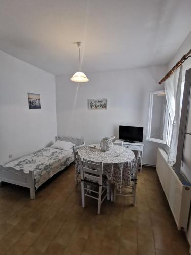 a room with a table and a bed and a television at Bralos Apartments in Patitiri