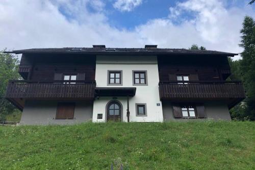 a house with two balconies on top of a field at Appartement mit Hüttenflair in Sankt Oswald
