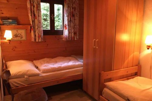 um pequeno quarto com duas camas num camarote em Appartement mit Hüttenflair em Sankt Oswald