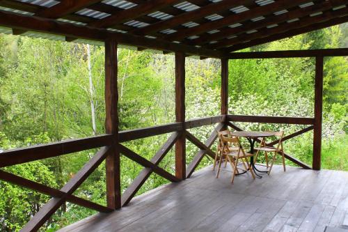 a screened porch with a table and chairs on it at Чан-садиба Гуцульська пісня in Mykulychyn