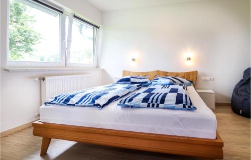 1 dormitorio con 1 cama con almohadas azules y blancas en Nice Home In Techelsberg With 1 Bedrooms And Wifi, en Techelsberg am Worthersee