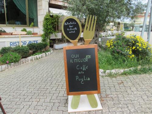 a sign for a restaurant with a fork on a sidewalk at Hotel Autostello in Castellana Grotte