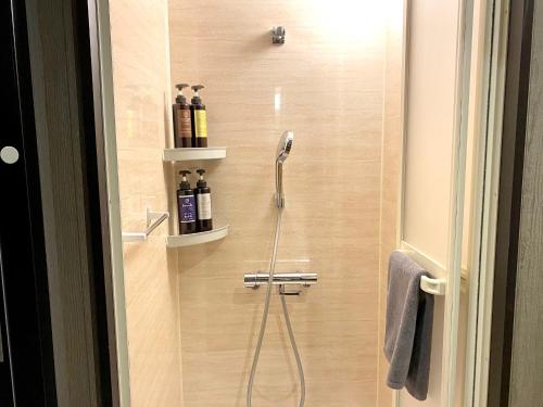 a shower with a shower head in a bathroom at Petit Hotel mio in Saitama