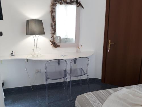 a bedroom with a desk with two chairs and a window at Villa Patrizia in La Spezia