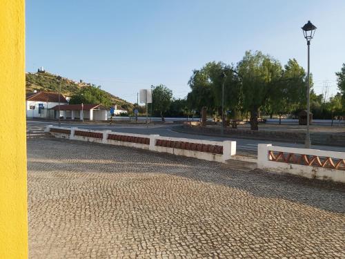 a road with a white fence and a street at Casa da Avó Velhinha in Telheiro