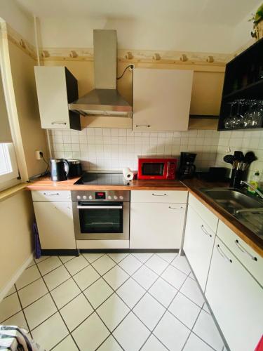 a kitchen with white cabinets and a red microwave at Fewo Dresden Zentrum Nähe Hauptbahnhof in Dresden