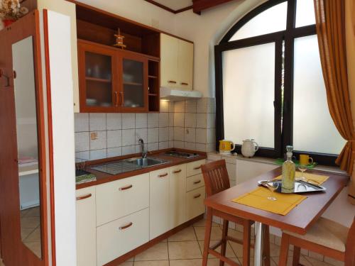 a kitchen with a table and a sink and a window at P&Z Apartments in Rab