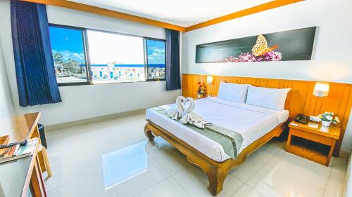 a bedroom with a bed with a butterfly on the wall at K2 Hotel @ Airport in Surat Thani