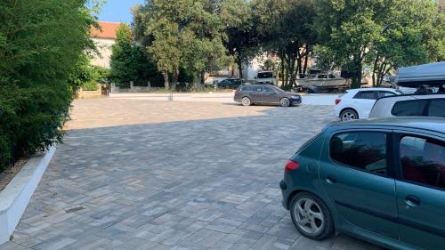 a parking lot with two cars parked in it at SUNSET VALA new beachfront apartment Pjescana Uvala - Medulin - Pula in Pješčana Uvala 