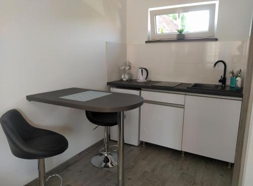 a small kitchen with a table and two stools at Dom Wypoczynkowy Willa Jar in Łeba