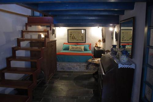 莫奈姆瓦夏的住宿－Blue Door (in the castle of Monembasia)，一间卧室设有一张床和一个螺旋楼梯