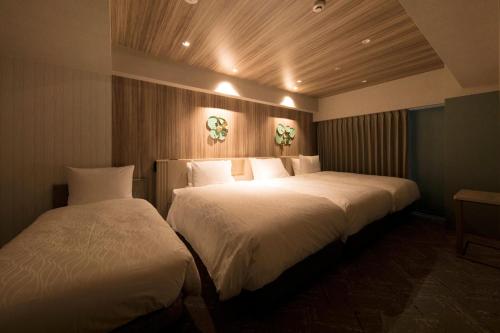 a hotel room with two beds in a room at Richmond Hotel Morioka Ekimae in Morioka