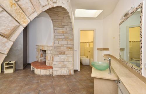 トッレ・デル・オルソにあるDamavi Suite 2のバスルーム(石造りの暖炉、シンク付)