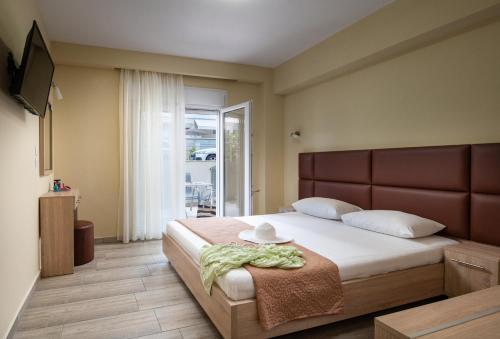 a bedroom with a large bed with a hat on it at Ioranna Studios - Sarti Sithonia in Sarti