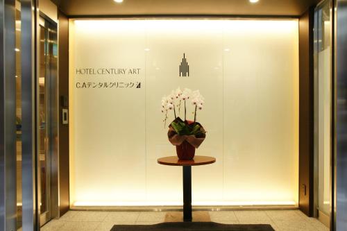 a display window with a vase of flowers on a table at Hotel Century Art in Fukuoka