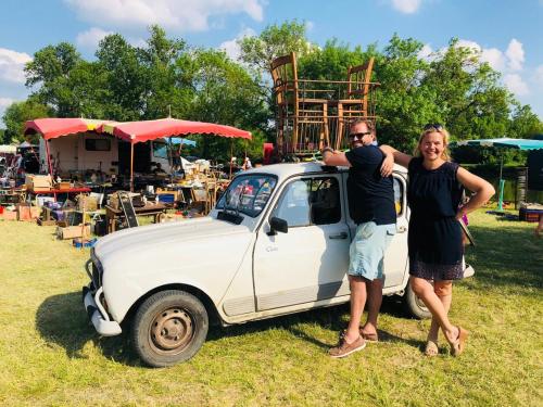 a man and a woman standing next to a white car at Côte du Jardin in Pouillé