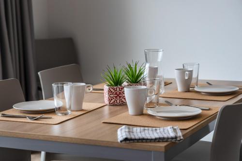 a wooden table with plates and glasses on it at Residence Solei Classic & Plus in Brenzone sul Garda