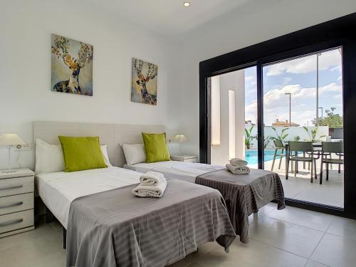 a bedroom with two beds and a view of a patio at Villa sol - Sucina - 3909 in Sucina