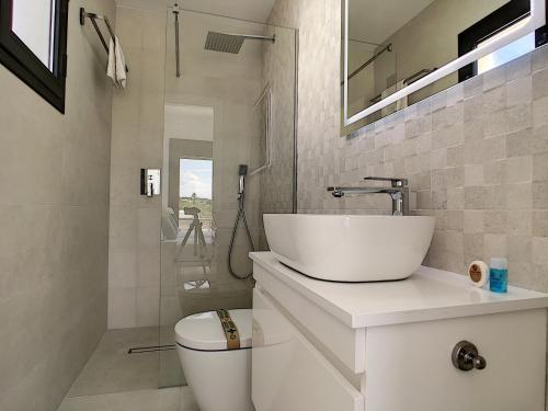 uma casa de banho branca com um lavatório e um WC em Villa sol - Sucina - 3909 em Sucina