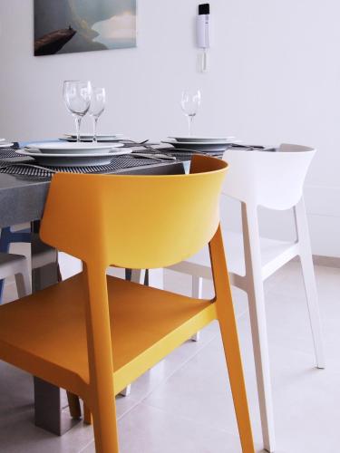 a dining table with a yellow chair in a dining room at Villa sol - Sucina - 3909 in Sucina