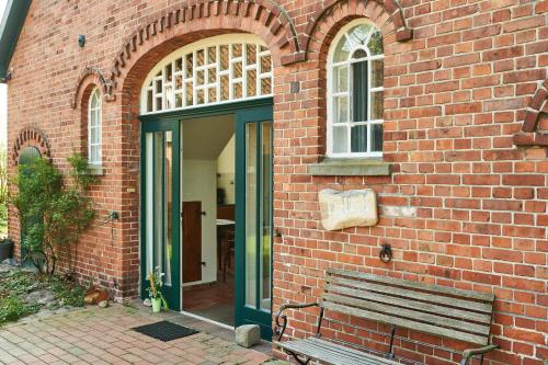 a brick building with a bench in front of it at Hürhus Hude in Hude