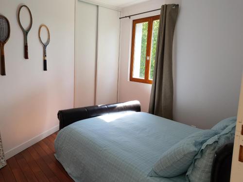 een slaapkamer met een bed en tennisrackets aan de muur bij TY ROZ in Roz-sur-Couesnon