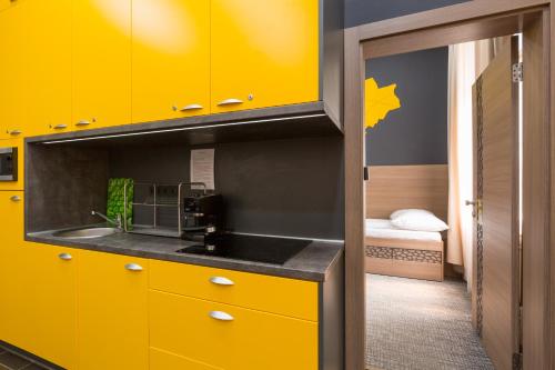 - une cuisine avec des placards jaunes et un évier dans l'établissement E14 Design Hostel, à Budapest