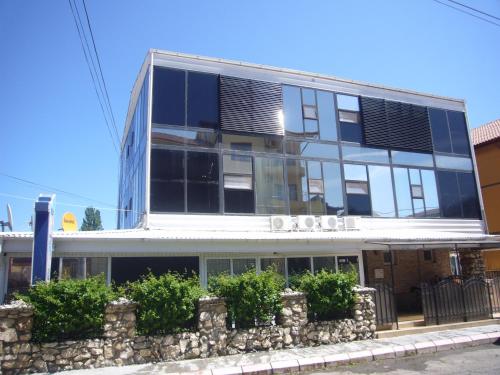 a building on a street with a stone wall at Villa Andreea in Eforie Nord