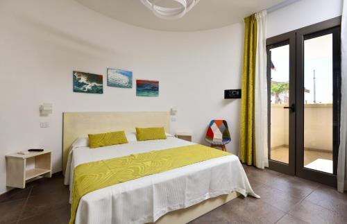 una camera da letto con un grande letto con una coperta gialla di Damavi Suite 2 a Torre dell'Orso