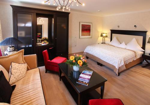 a hotel room with a bed and a living room at Deidesheimer Hof in Deidesheim