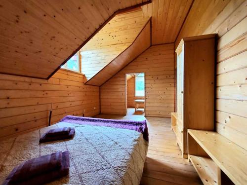 a room with a bed in a wooden cabin at Марканна in Petrashani