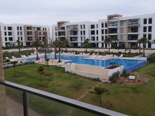 - une vue sur la piscine dans un complexe d'appartements dans l'établissement Presigia plage des nation Vacation Home, à Sidi Bouqnadel