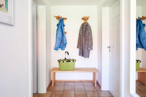 a hallway with a table and clothes hanging on a wall at Lütje 11 in Hude