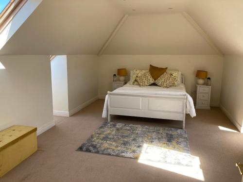 a bedroom with a white bed and a rug at Links Close, Rosslare Strand, Ireland in Rosslare