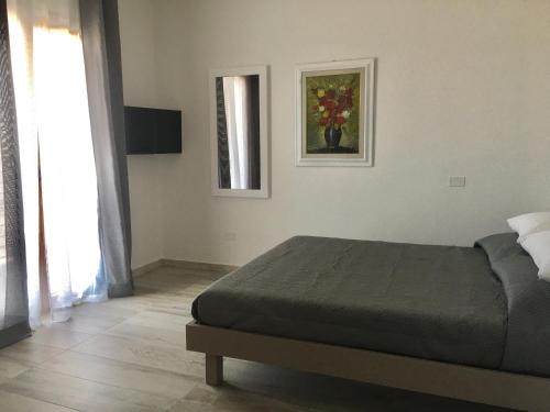 a bedroom with a bed and a painting on the wall at Villa INN in Villaperuccio