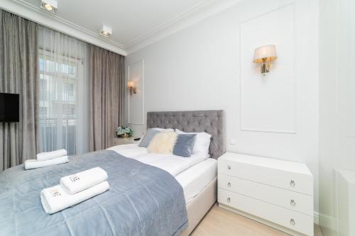 sypialnia z dużym łóżkiem i dwoma ręcznikami na nim w obiekcie Cristal - Neptun Park by OneApartments w Gdańsku