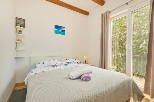 ein weißes Schlafzimmer mit einem großen Bett mit Handtüchern darauf in der Unterkunft Santa Barbara Mljet apartment in Babino Polje