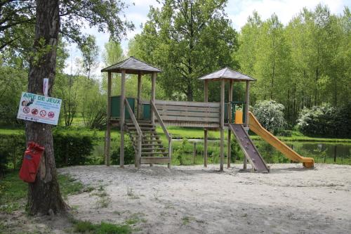 un parc avec une aire de jeux avec un toboggan et un arbre dans l'établissement La Sensation, à Matringhem