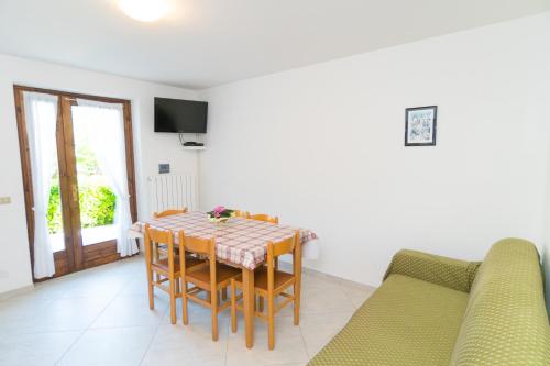 a dining room with a table and a couch at Casa Alberta in Pieve Di Ledro